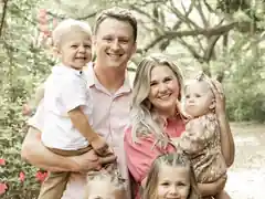 Dr. Jordan Henke with his wife, Mia, and their four children outdoors.