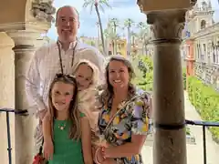 Dr. William Donovan standing with three family members in a historic outdoor courtyard.